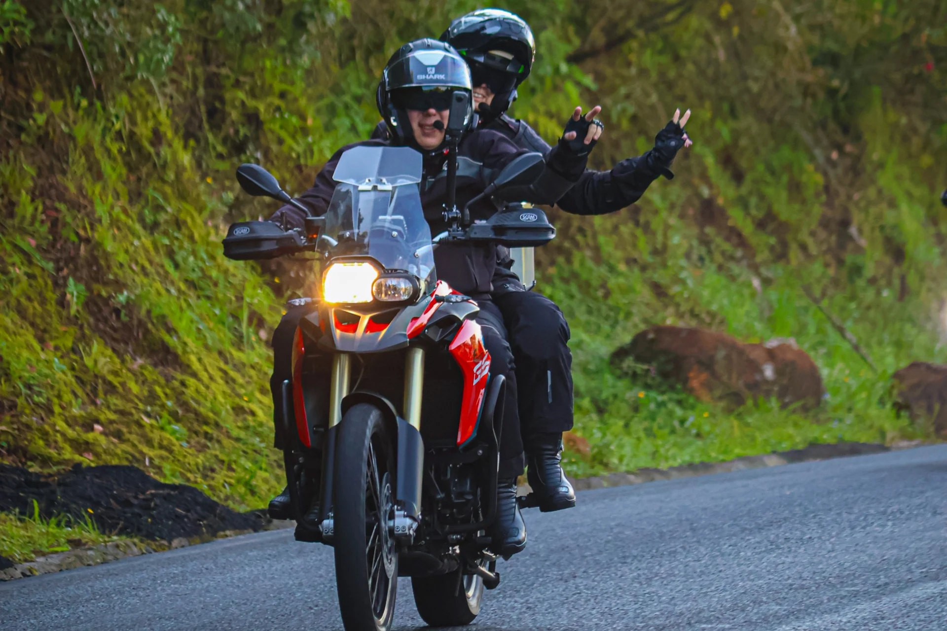 Viagem de motocicleta por uma estrada entre montanhas verdes